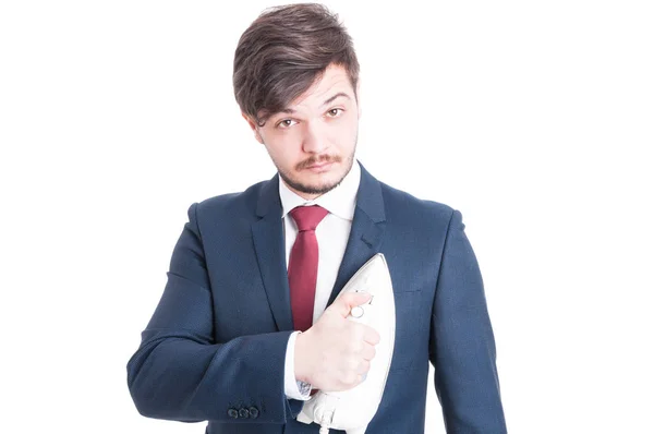 Mannen bär kostym holding ett strykjärn på sin jacka — Stockfoto