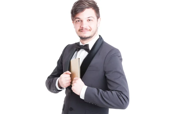 Handsome man wearing tuxedo and bowtie holding notebook — Stock Photo, Image