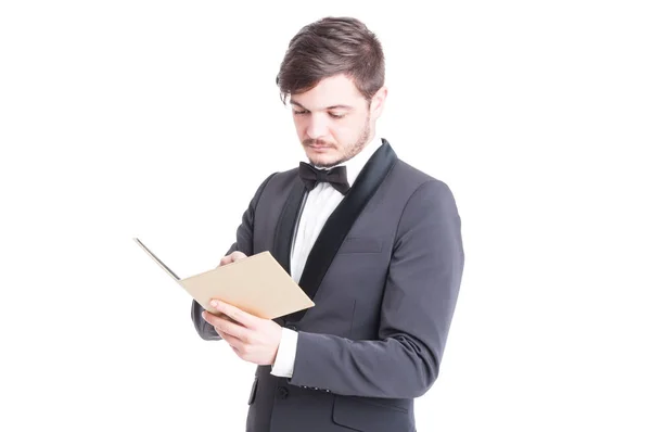 Stilig man klädd i smoking och bowtie titta på anteckningsboken — Stockfoto