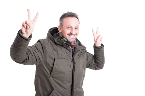 Mann posiert mit Winterjacke und zeigt Friedensgeste — Stockfoto