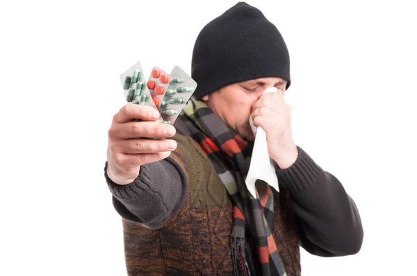Homem com congestão nasal mostrando pílulas — Fotografia de Stock