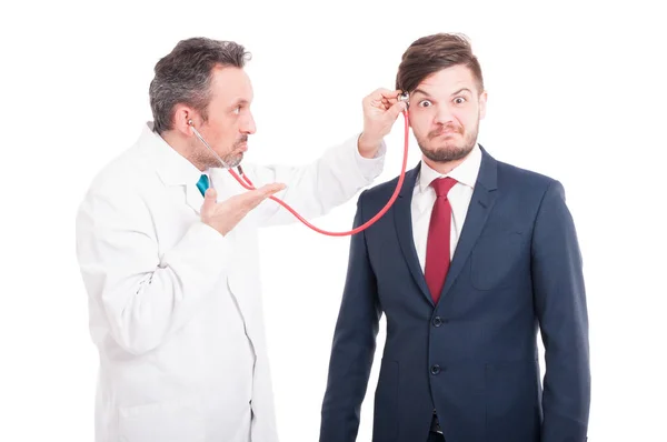 Professional medic cheking  head of insane lawyer — Stock Photo, Image