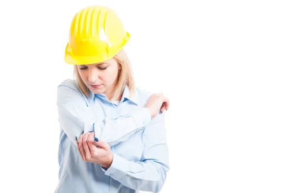 Architecte féminine portant un casque vérifiant son coude pour des blessures — Photo