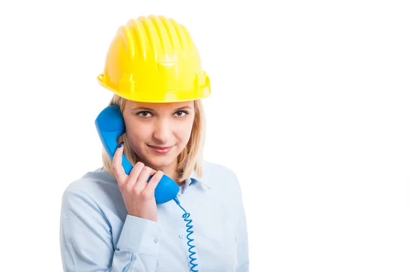 Female engineer wearing helmet holding telephone receiver — Stock Photo, Image