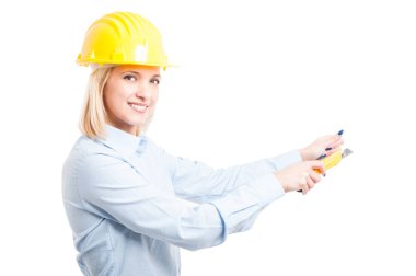 Kesici aracını kullanarak kask giyen kadın mimar