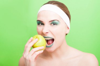 Kadın bir taze elma ısırmaya çalışır