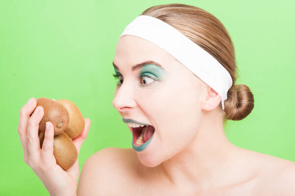 Young woman holding fresh kiwi fruit