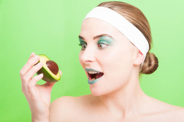 Pretty young woman holding avocado