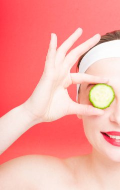 Bir dilim salatalık tutan kadın portresi