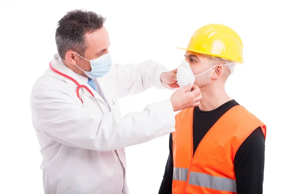 Männlicher Arzt setzt Zeichen im Gesicht des Bauarbeiters — Stockfoto