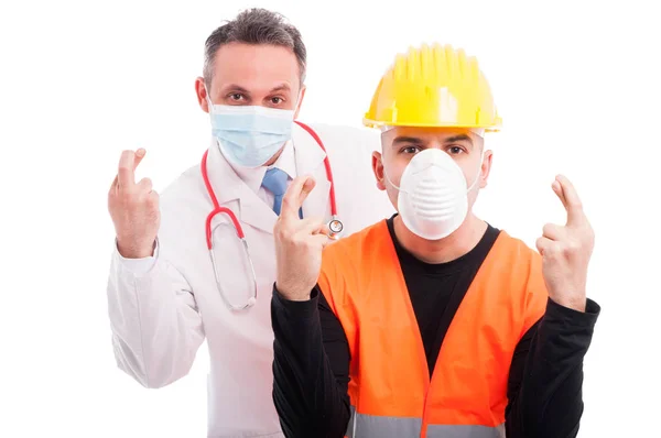 Doctor and constructor showing fingers crossed gesture — Stock Photo, Image