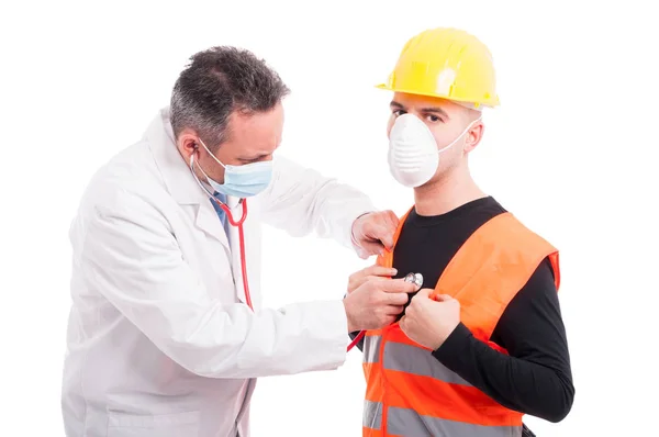 Doctor listening to constructors breath with stethoscope — Stock Photo, Image