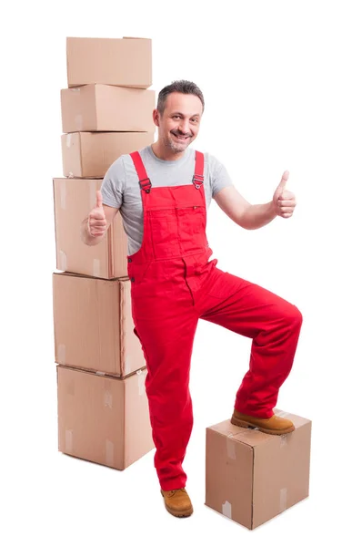 Sorridente uomo motore mostrando come in piedi intorno scatole — Foto Stock