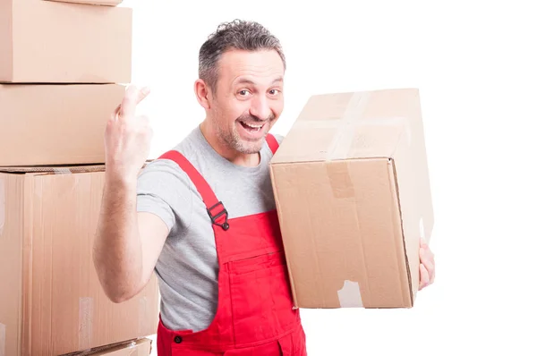 Portrait of mover smiling man holding box showing fingers crosse — Stock Photo, Image