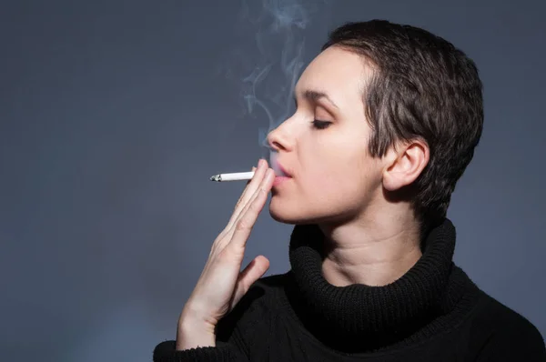 Profil der rauchenden jungen Frau — Stockfoto