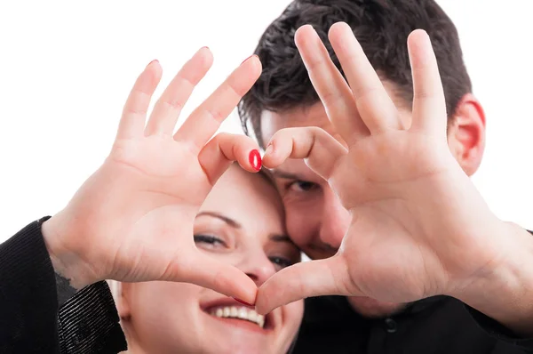 Pareja joven cogida de la mano en forma de corazón — Foto de Stock