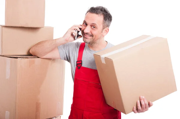 Mover man holding box talking at phone and smiling — Stock Photo, Image