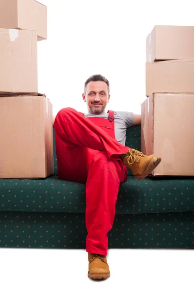 Mover homem sentado no sofá com caixas de papelão ao redor — Fotografia de Stock