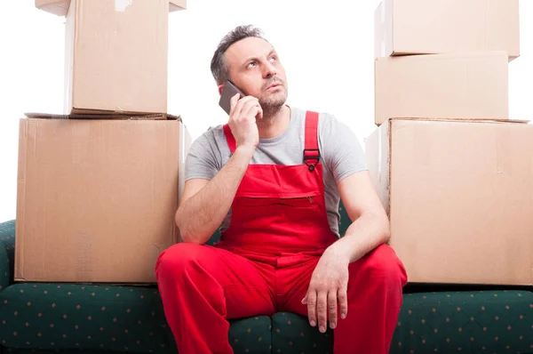 Mover man sitting on couch talking at phone — Stock Photo, Image