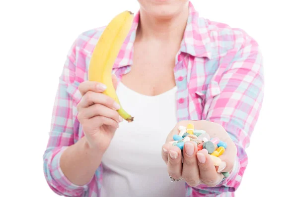 Frau hält Banane und Tabletten in der Hand — Stockfoto