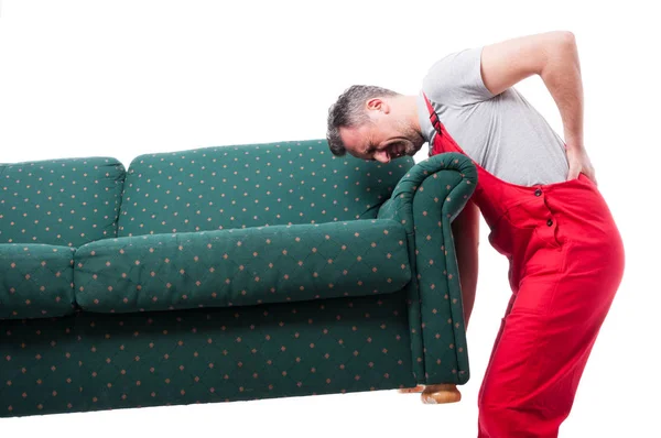 Μετακινούμενος τύπος ανασηκώνοντας ένα βαρύ καναπέ έχοντας πόνο στην πλάτη — Φωτογραφία Αρχείου