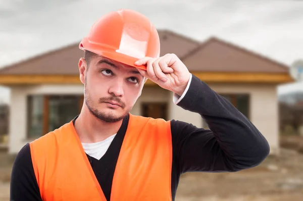 Retrato de un constructor guapo sosteniendo su casco — Foto de Stock