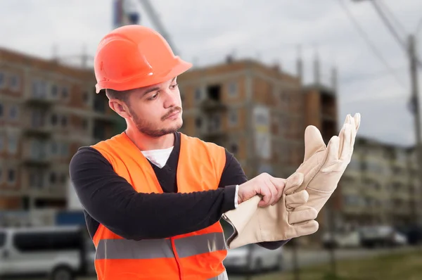 Bauarbeiter zieht Schutzhandschuhe an — Stockfoto
