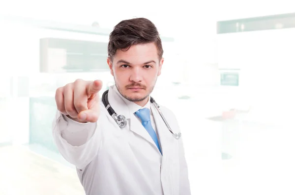 Handsome young doctor pointing finger at you