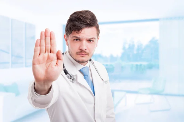 Злой врач-мужчина с отталкивающим жестом — стоковое фото