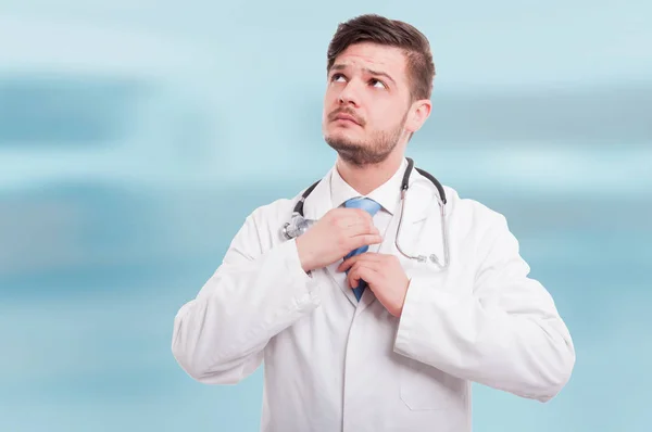 Médico varón de uniforme blanco ajustando su corbata —  Fotos de Stock