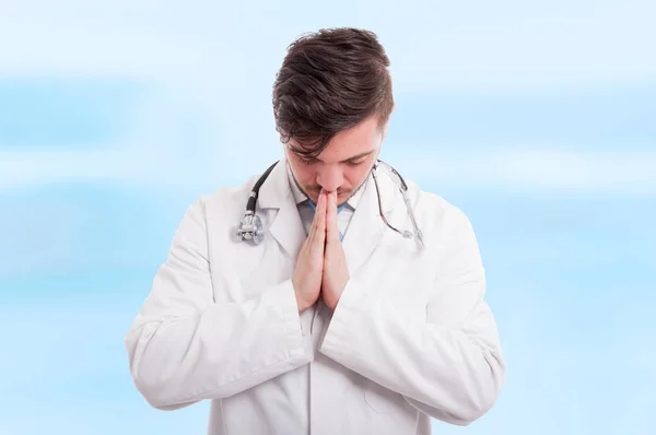 Médico macho rezando com as mãos apertadas — Fotografia de Stock