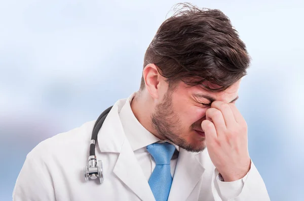 Closeup de médico jovem cansado com dor de cabeça — Fotografia de Stock