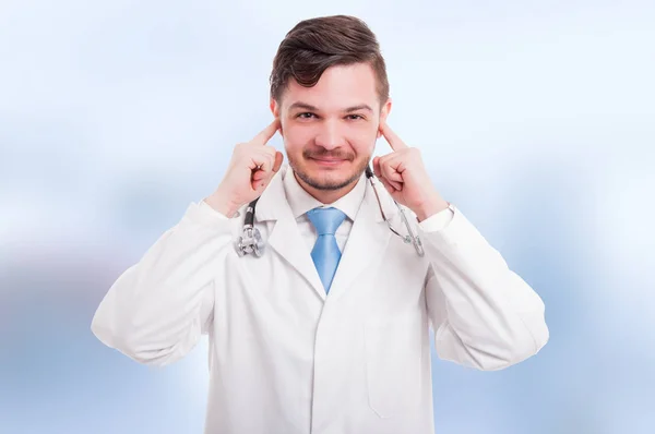 Médico atraente feliz cobrindo seus ouvidos — Fotografia de Stock