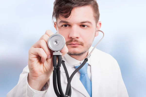 Gros plan du jeune médecin masculin qui écoute avec stéthoscope — Photo