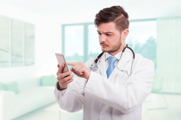 Médico moderno navegando algo en el teléfono inteligente — Foto de Stock