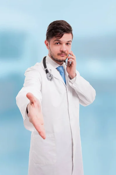 Medic doing handshake gesture while he's on phone — Stock Photo, Image