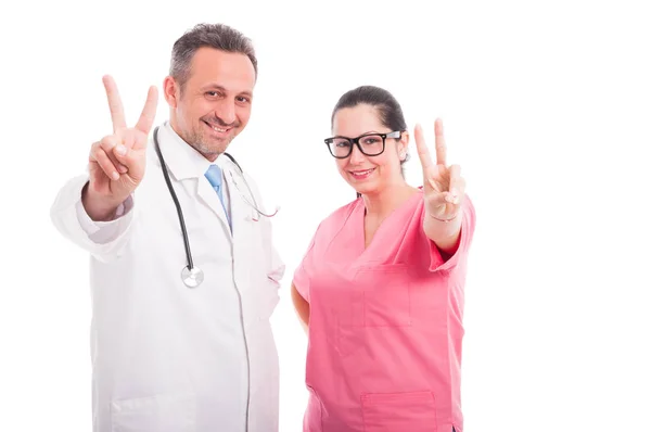 Médico exitoso y enfermera haciendo gesto de paz —  Fotos de Stock