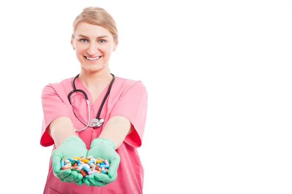 Friendly medical nurse lady smiling showing lots of pills — Stock Photo, Image