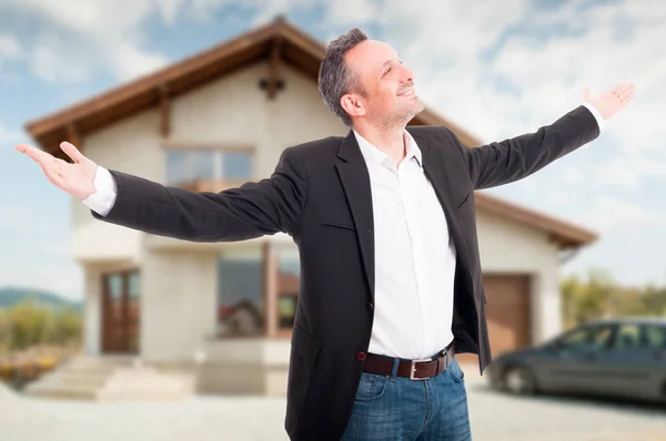 Feliz agente inmobiliario parado afuera con los brazos extendidos — Foto de Stock