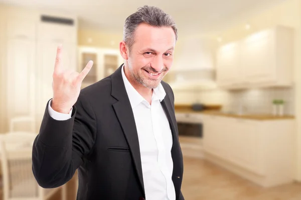 Junge Immobilienmaklerin macht Rock-Geste — Stockfoto