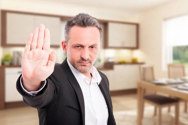 Agente inmobiliario serio mostrando gesto de stop — Foto de Stock