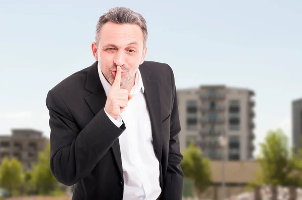 Fastighetsmäklare med finger på läpparna gör tystnad gest — Stockfoto