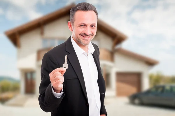 Jeune agent immobilier offrant des clés de maison — Photo