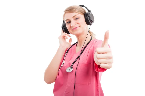 Female nurse listening to headset showing like — Stock Photo, Image