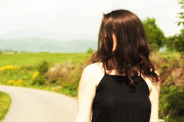 Jolie jeune femme en plein air debout dans la lumière du soleil — Photo