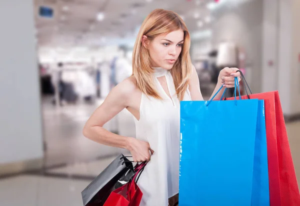 Schattig meisje met boodschappentassen staat bij shop — Stockfoto