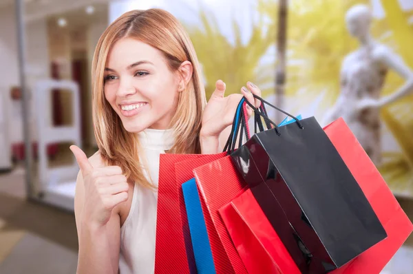 Gelukkig meisje tonen als gebaar om te winkelen — Stockfoto