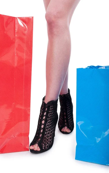 Pernas de menina bonita perto de sacos de compras — Fotografia de Stock