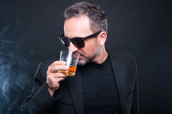 Hermoso millonario disfrutando de un vaso de whisky — Foto de Stock