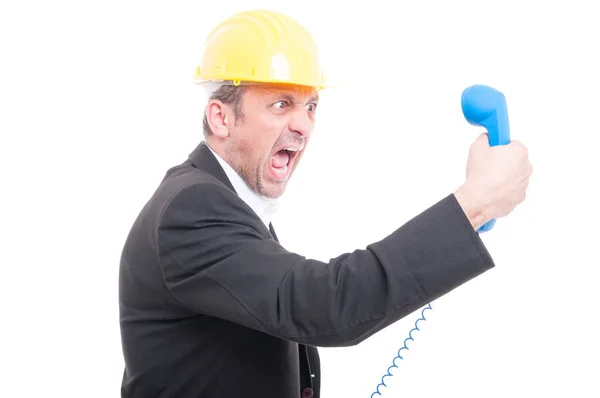 Side view of architect yelling at big blue telephone receiver Stock Photo